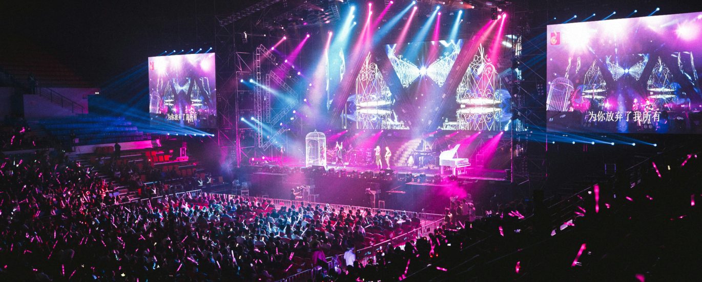 Colorful live concert with vibrant lighting, energetic crowd, and dynamic stage performance.