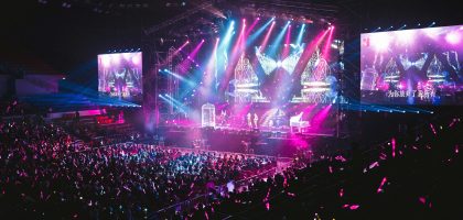Colorful live concert with vibrant lighting, energetic crowd, and dynamic stage performance.