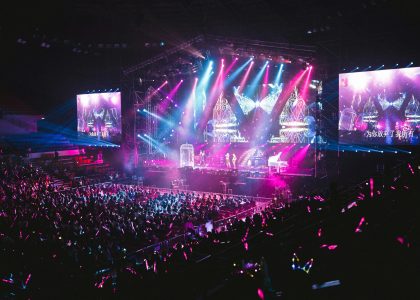 Colorful live concert with vibrant lighting, energetic crowd, and dynamic stage performance.